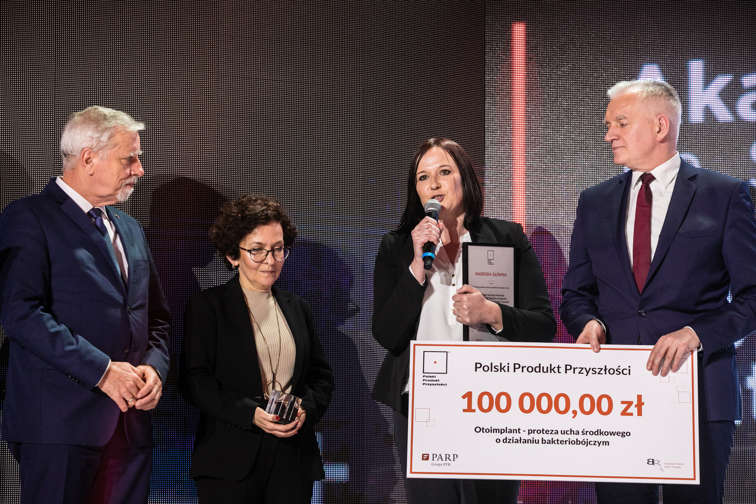 Na zdjęciu Wojciech Kamieniecki i Jarosław Gowin wręczają czek z kwotą 100 000,00 zł dwóm  młodym kobietom;