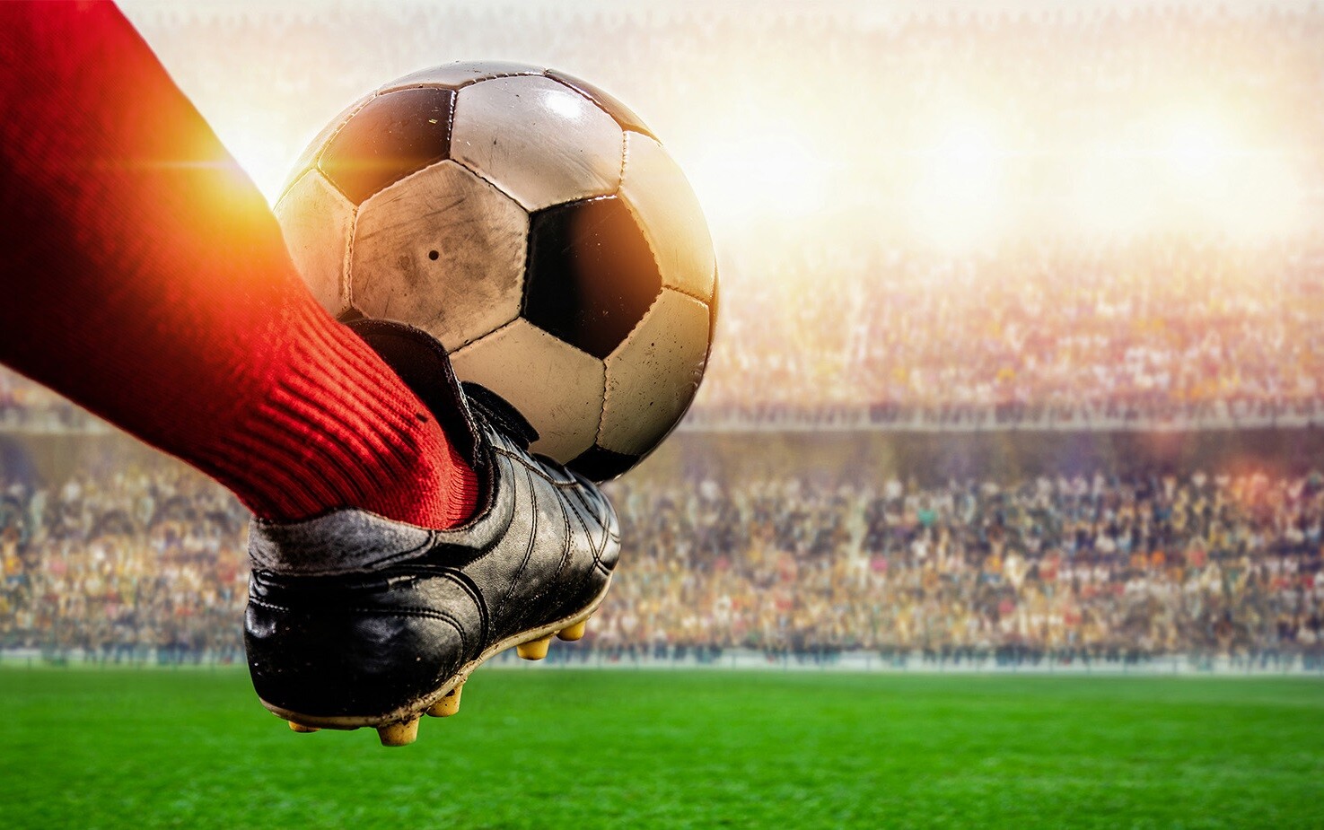 Stopa i piłka, w tle stadion.