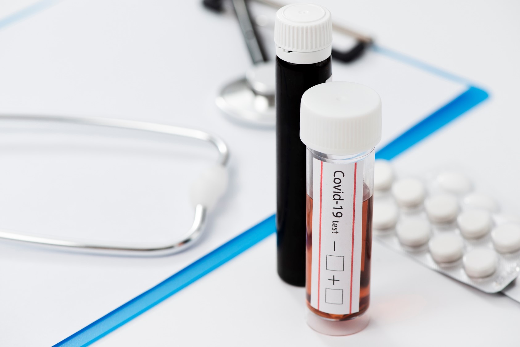 Próbki z krwią do badania, z prawej strony tabletki, z lewej strony widać stetoskop. 