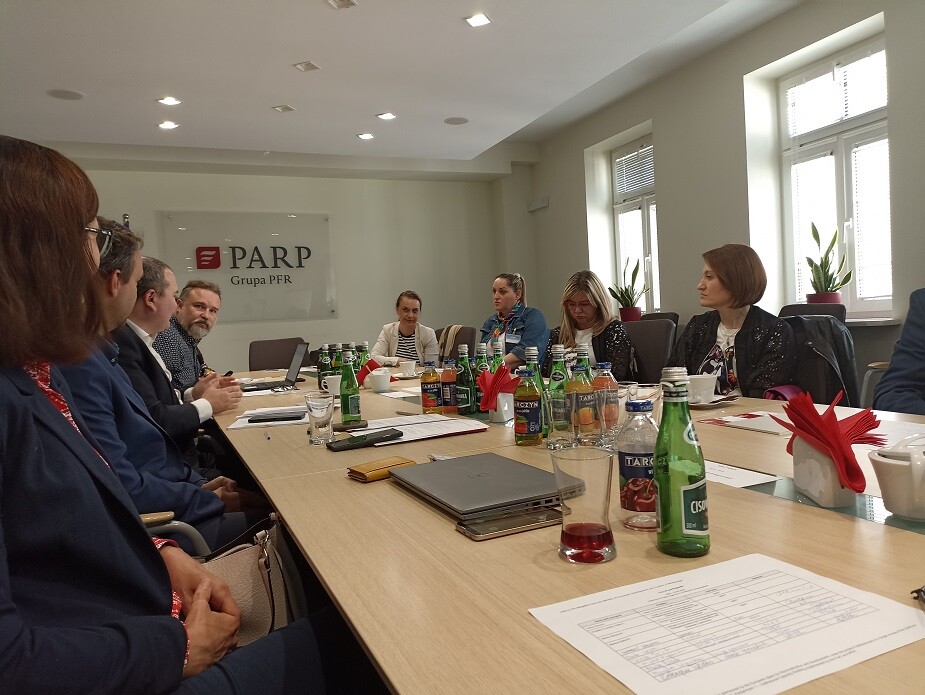 ludzie siedzą przy stole konferencyjnym i rozmawiają