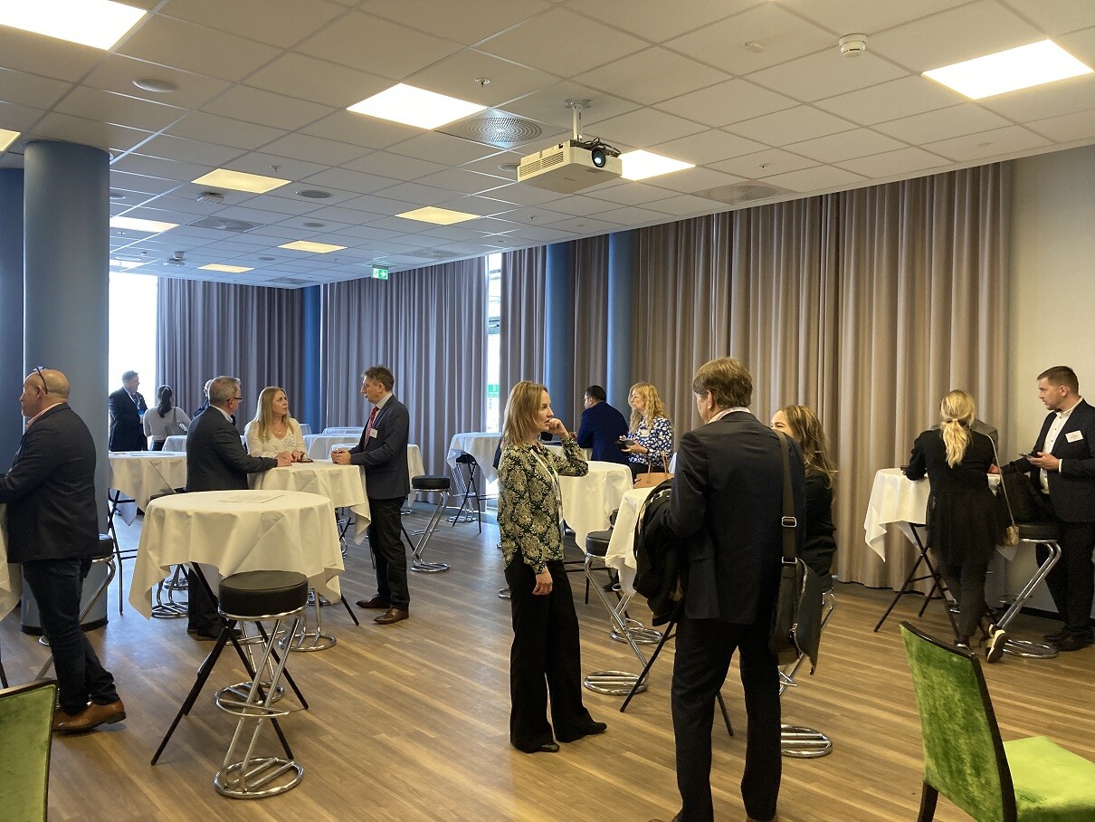 ludzie stoją przy stolikach i rozmawiają