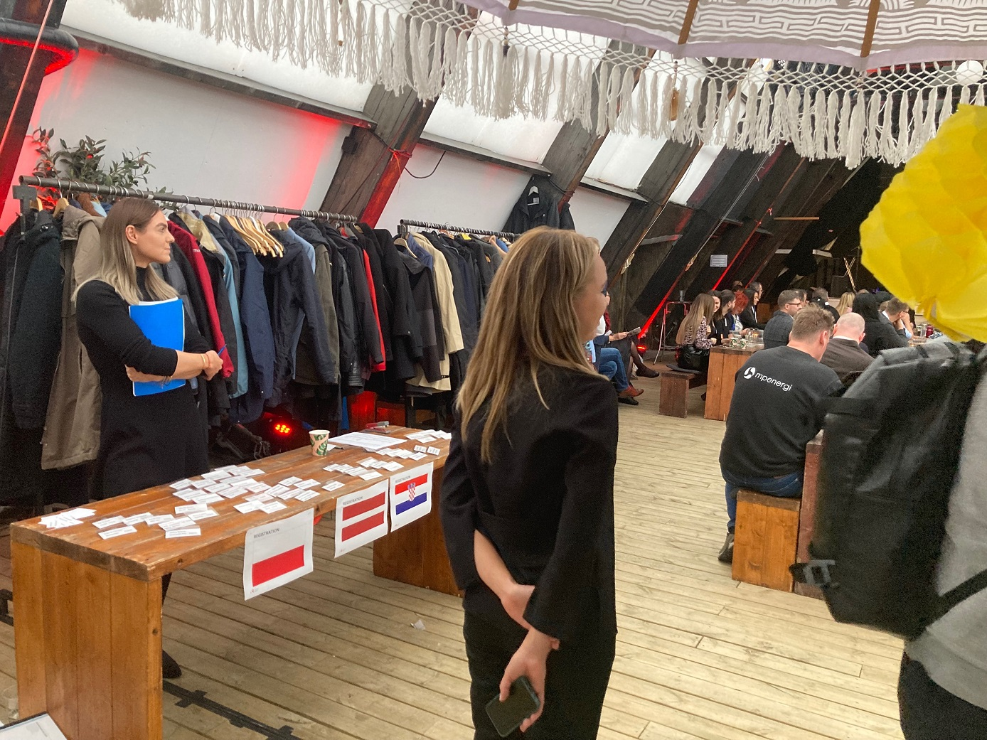 Ujęcie na drewniany blat przy którym stoi młoda kobieta