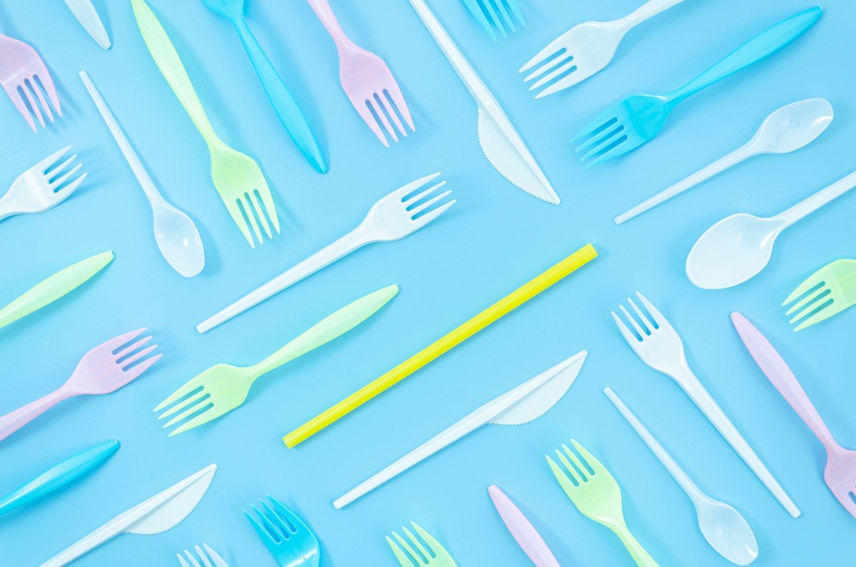 Kolorowe plastikowe widelce na niebieskim tle