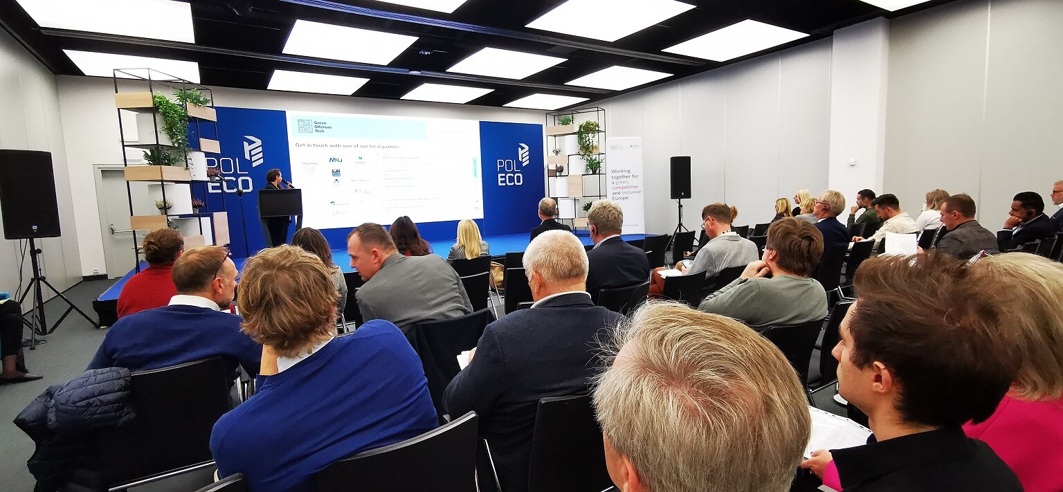 Ludzie siedzą na sali i patrzą się w telebim