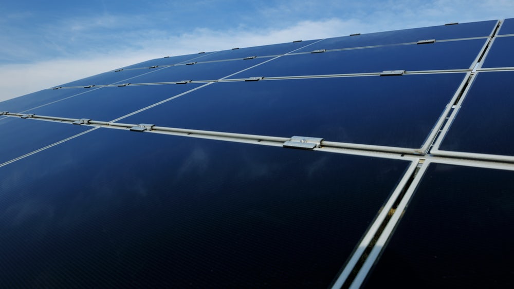 widok na grupę modułów składających się z prostokątnych paneli solarnych. Są pokryte czarnym szkłem i połączone specjalnym systemem montażowym