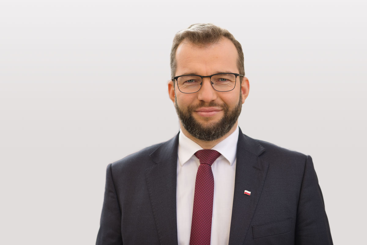 Zdjęcie mężczyzny Grzegorza Pudy ministra funduszy europejskich i polityki regionalnej w czarnym garniturze i białej koszuli z krawatem