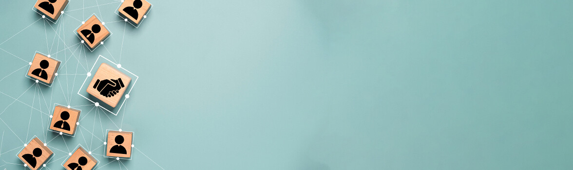 Grafika z kostkami. Na jednej kostce jest uścisk dłoni, a na pozostałych postacie.