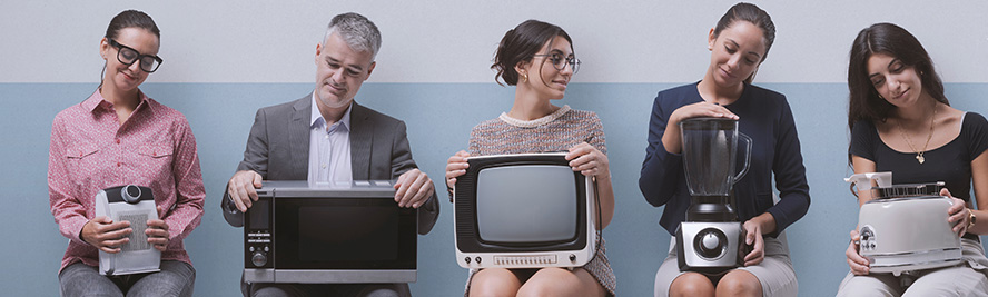 Ludzie trzymający na kolanach mały sprzęt AGD