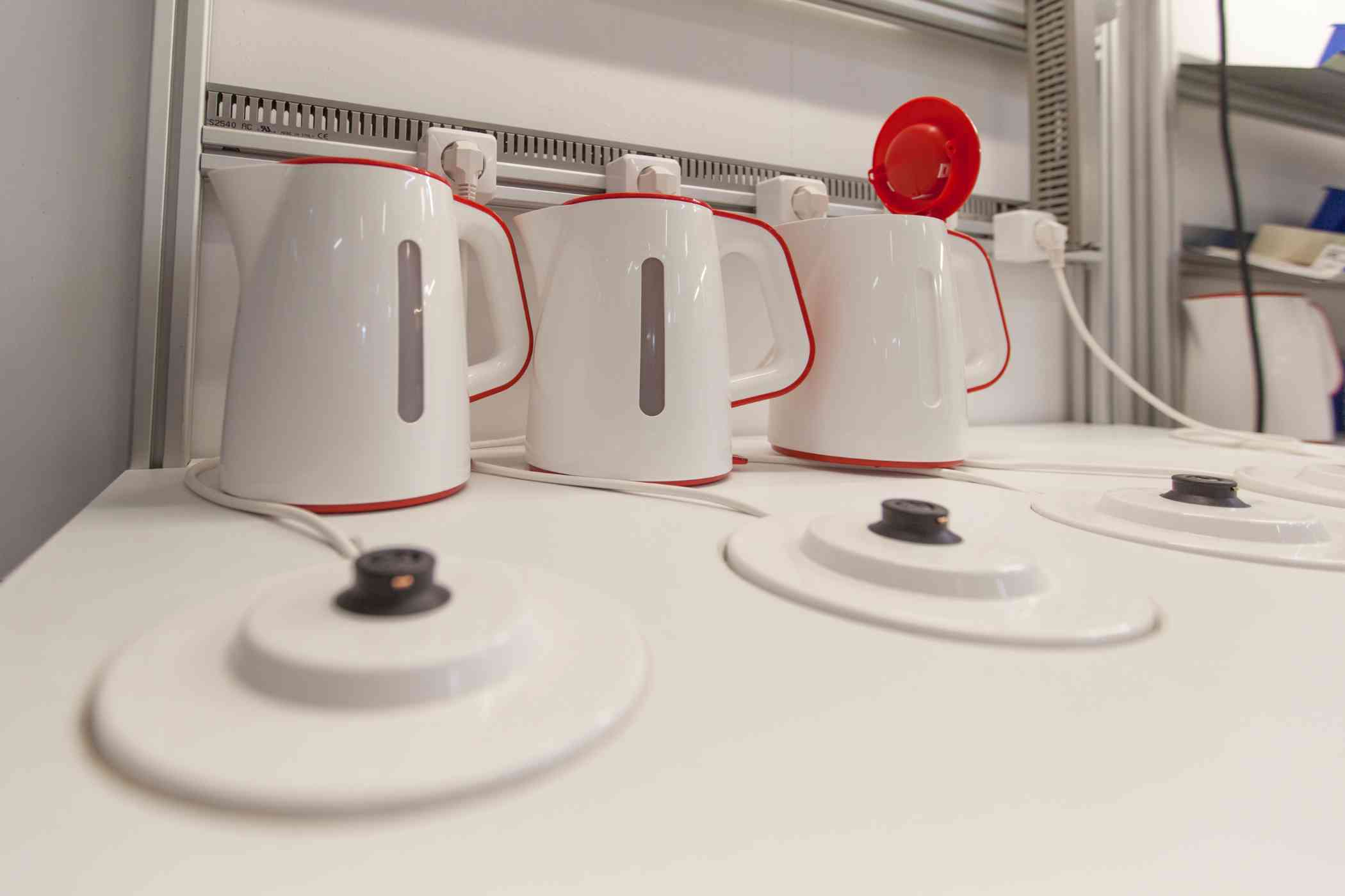 Czajniki elektryczne ustawione w rzędzie, stoją na blacie