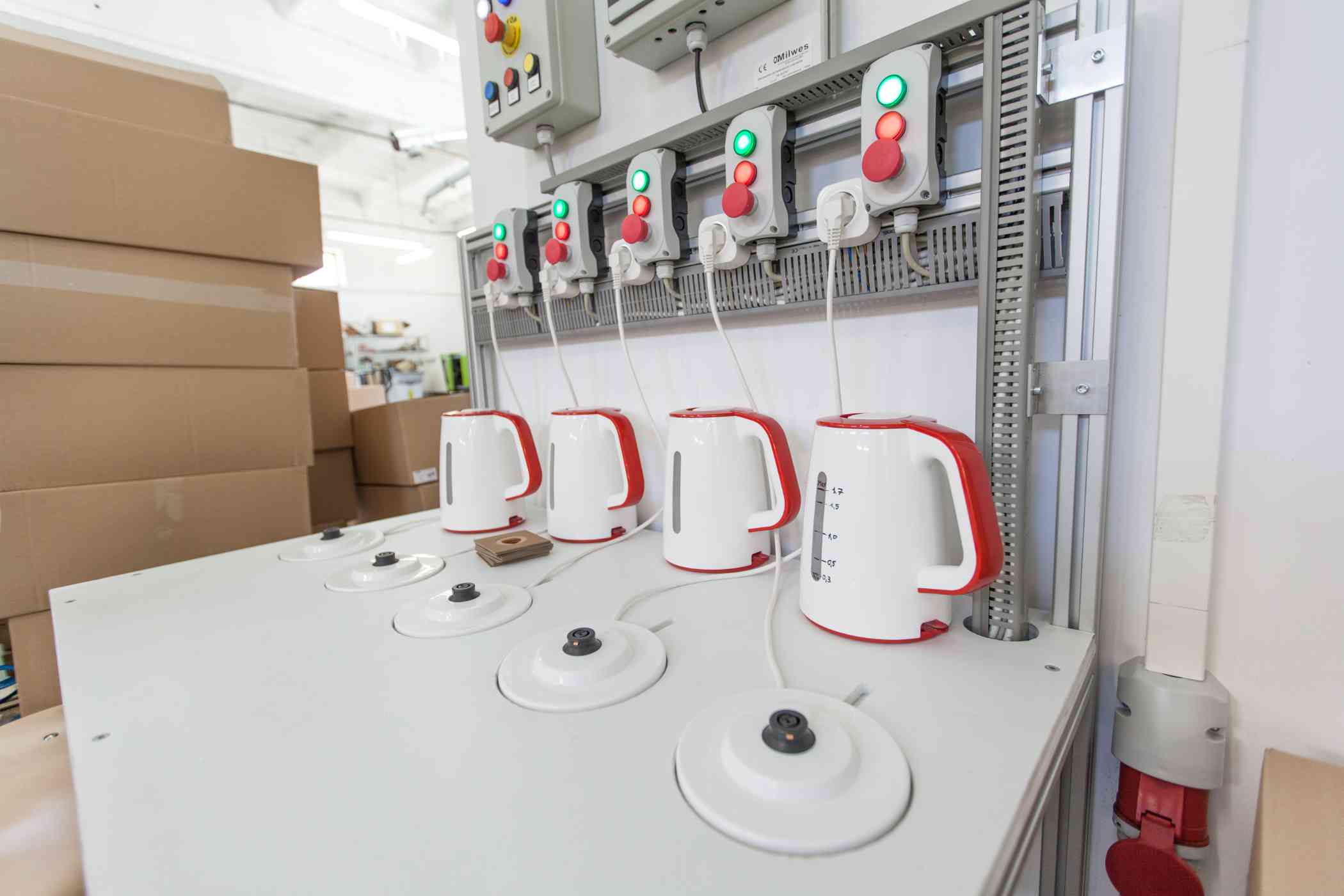 Sala produkcyjna, czajniki elektryczne stoją na blacie.