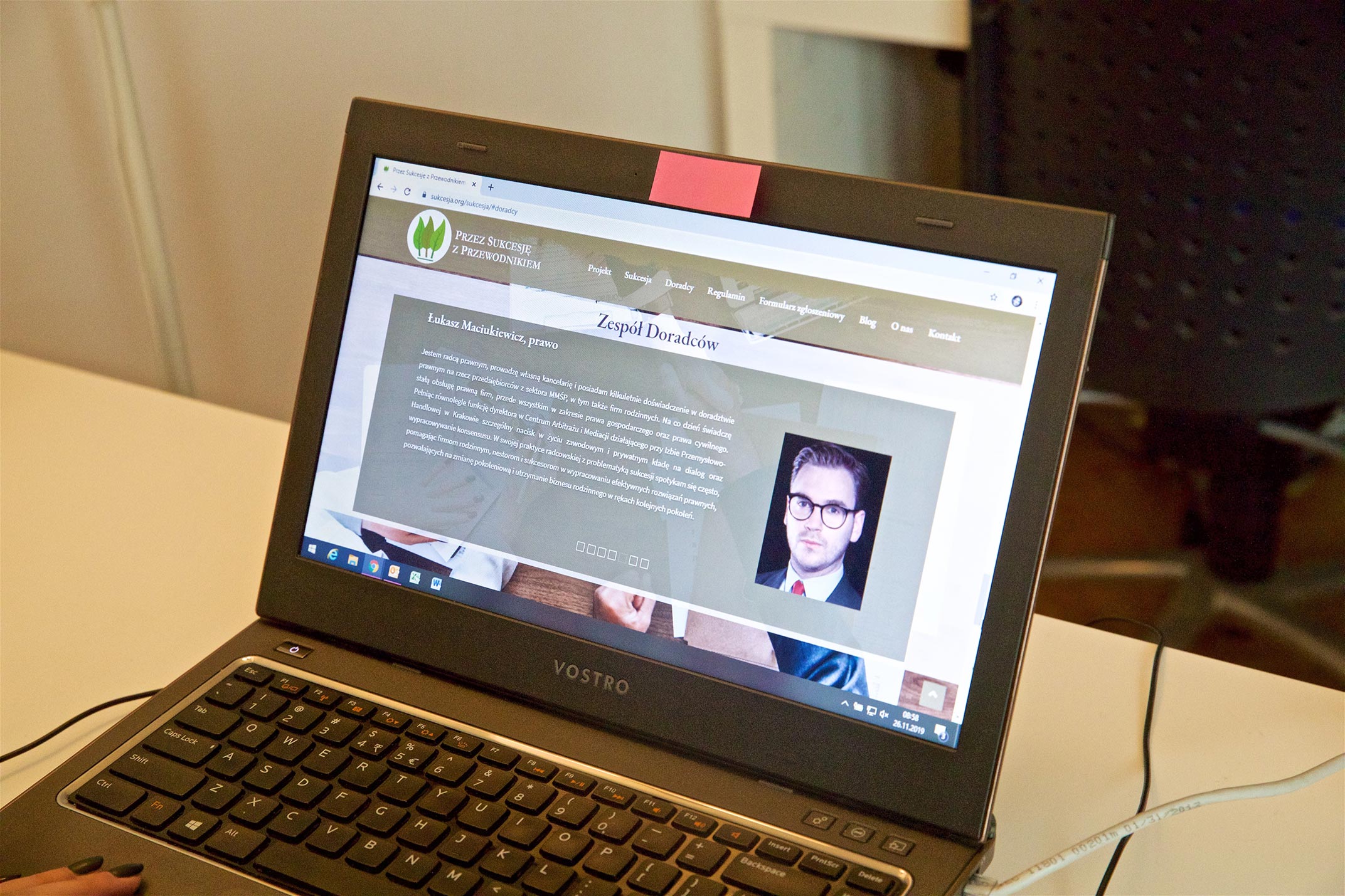 Laptop, na którym widać stronę internetową Przez sukcesję z przewodnikiem