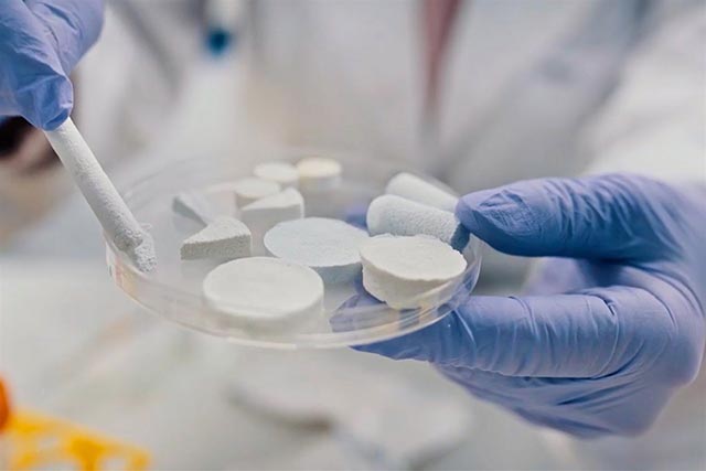 Widok dłoni trzymających podstawkę z umieszczonym materiałem przykładowych form kompozytu