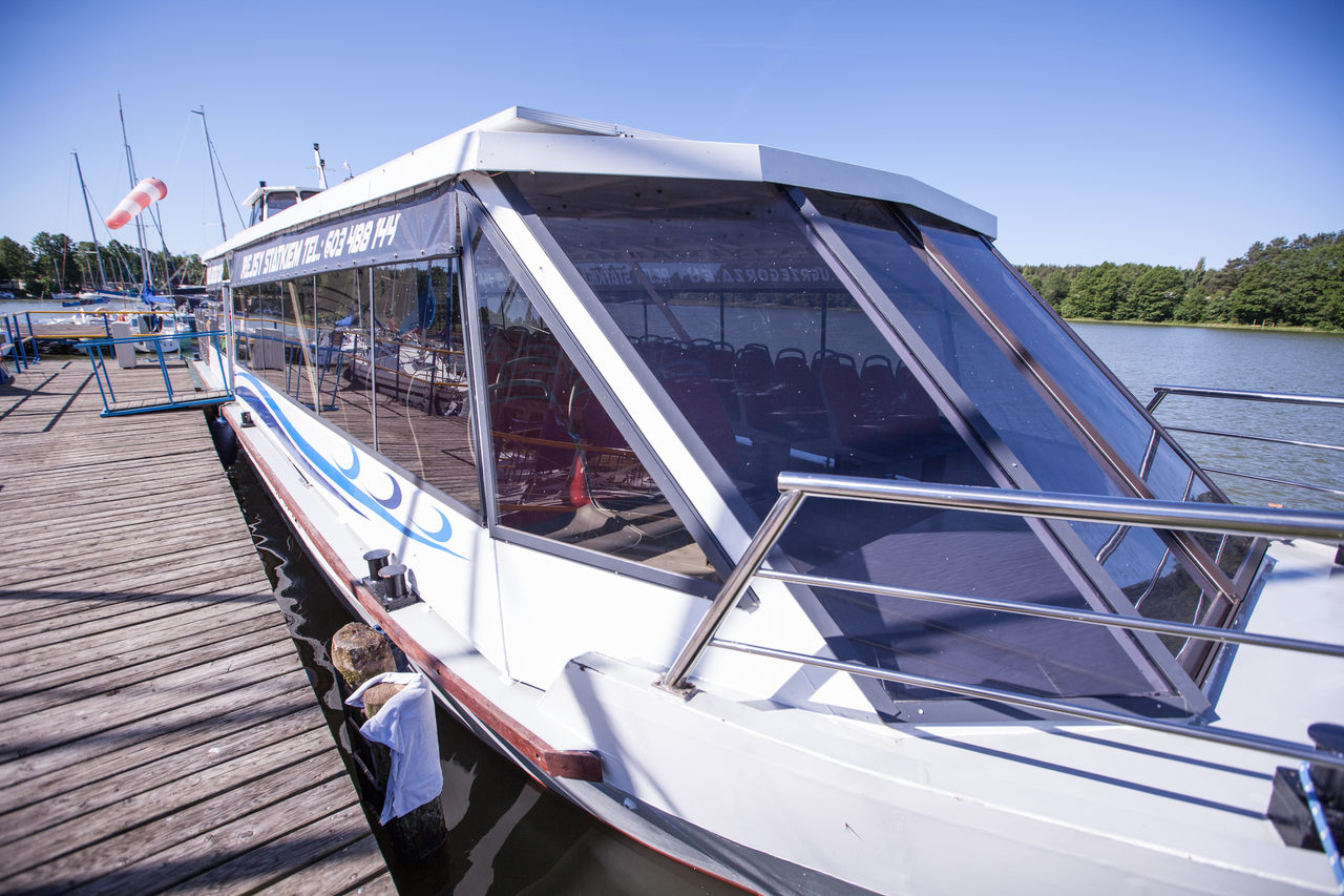 Zacumowany jacht, w oddali drzewa